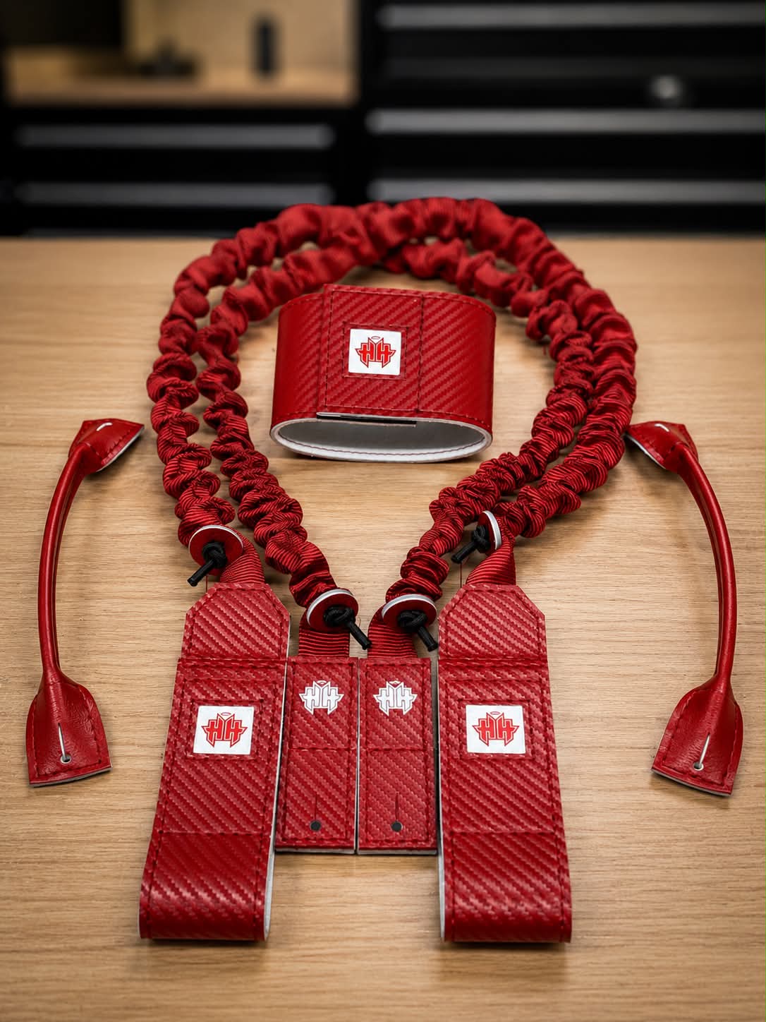 Red carbon fiber Suspenders 2.0 on a wood work bench