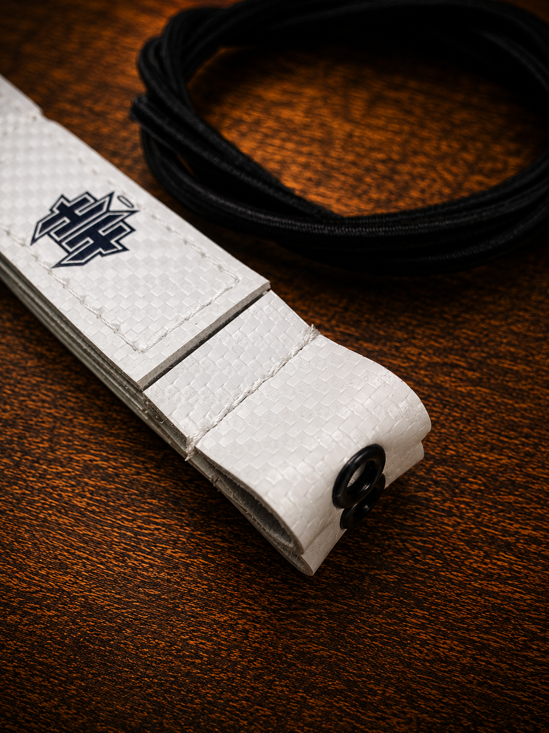 Closeup detail of the reinforcement eyelet on white Halo Hockey Posi-Lock goalie toe ties
