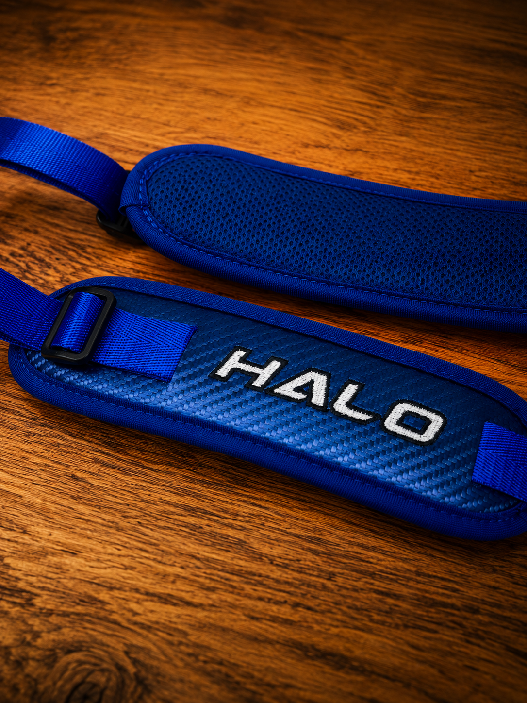 Closeup of blue Halo Hockey Rotation Doctor goalie pad straps showing the front and back