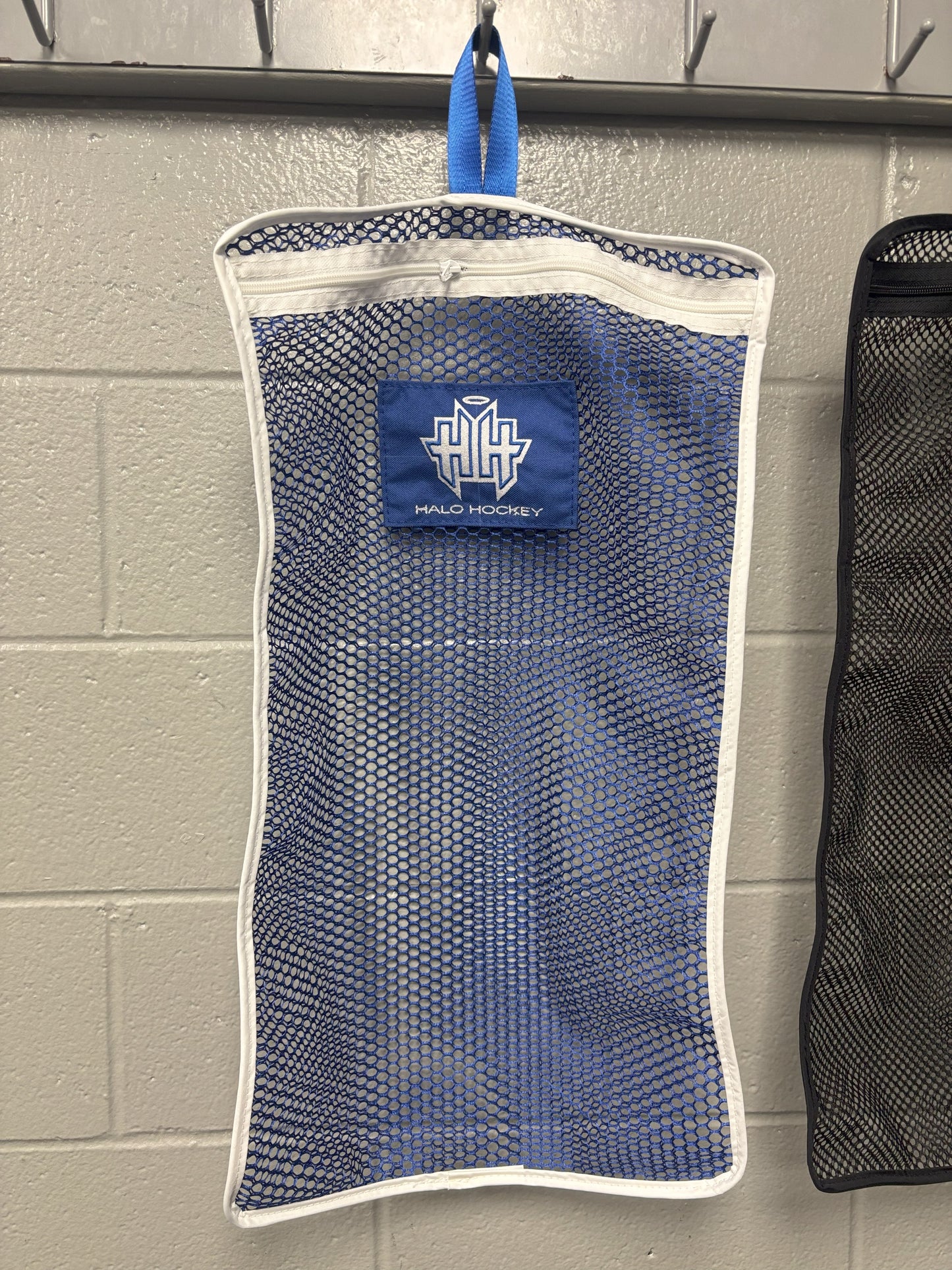 Halo Hockey Stinky Boy Laundry bag shown in blue color option hung on a locker room wall hooks