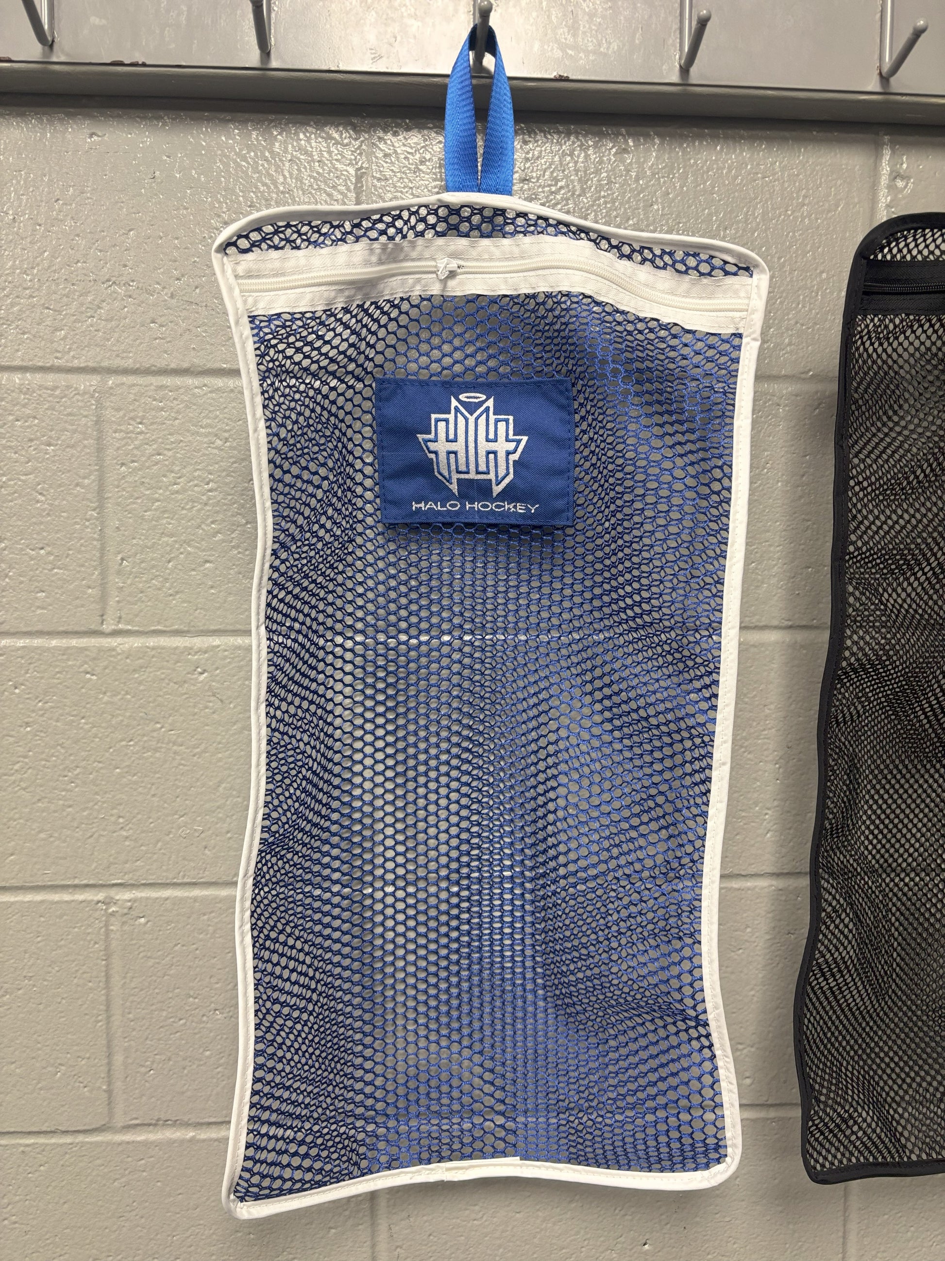 Halo Hockey Stinky Boy Laundry bag shown in blue color option hung on a locker room wall hooks
