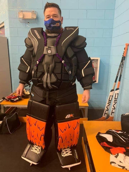 Black carbon fiber Halo Hockey Suspenders 2.0 with purple logos and center strap option being worn by a hockey goalie